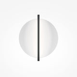 The Mira LED Wall Light - Black With White Diffuser features a minimalist circular white shade split by a slim black bar. Its mounted on a plain white background, highlighted by its sleek black metal frame, providing refined ambient lighting throughout the space.