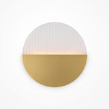 The Jupiter LED Wall Light 6W 3000K in Brass & White offers a minimalist style, with a textured design and smooth gold bottom. It emits a soft warm glow from the center, creating ambient lighting and a gentle gradient effect on the white portion.