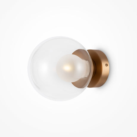 The Basic form Small Clear Ball Wall Light - Gold boasts a clear glass globe with a frosted bulb, elegantly mounted on a gold base for a sleek, sophisticated look.