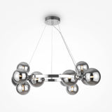 The Dallas 11 Light Suspension features a circular metallic frame with multiple spherical chrome lights and smoked glass, suspended from thin wires. This sleek, contemporary chandelier enhances any space against a plain white background.