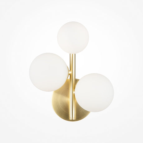 The Dallas 3 Light Wall Light features a brass base and three white opal glass globes arranged in a triangular pattern, combining metallic and matte finishes for contemporary flair.