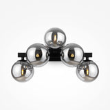 The Dallas 5 Light Wall Light - Black With Smoked Mirrored Glass is a modern fixture for contemporary spaces with five spherical metallic bulbs in a semi-circular pattern. Each bulbs smoked mirrored glass enhances the sleek design by reflecting light beautifully.