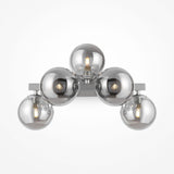 The Dallas 5 Light Wall Light in chrome showcases five spherical bulbs arranged in a triangular design. With clear bulbs revealing glowing filaments, its sleek metallic base is complemented by an elegant smoked mirrored glass finish.