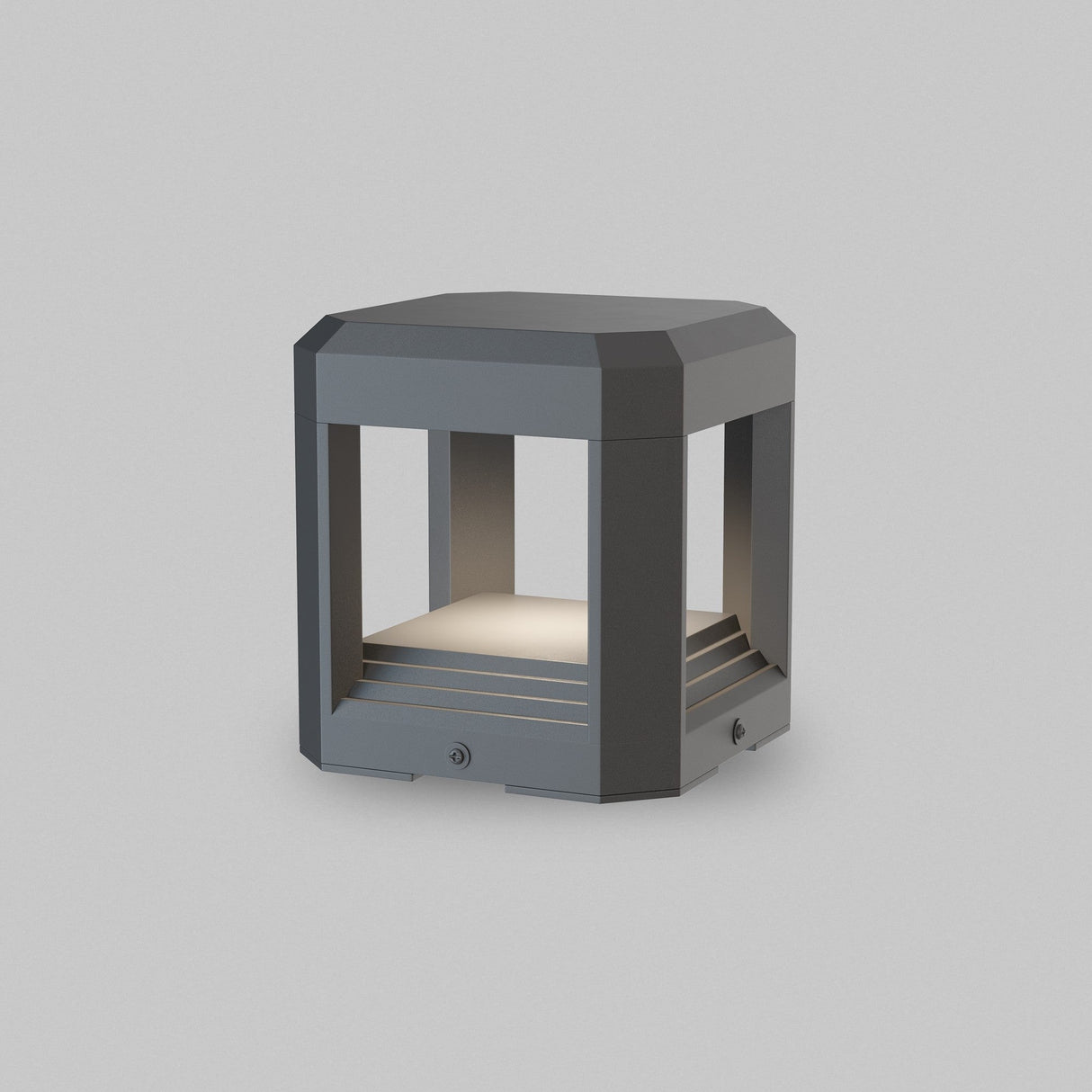 The Royal Mile LED Square Pedestal Light - Grey is a modern outdoor lamp with a die-cast aluminum body and matte gray finish. It features an open rectangular frame that emits a soft white glow, offering IP65 protection for durability.