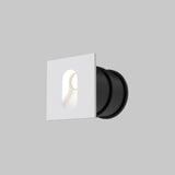 The Via Urbana Outdoor LED Recessed Wall Light 4000K 3W - White features a minimalist white square design with a rounded black base. Its an IP54 rated fixture that offers a modern and sleek appearance against a plain gray background.