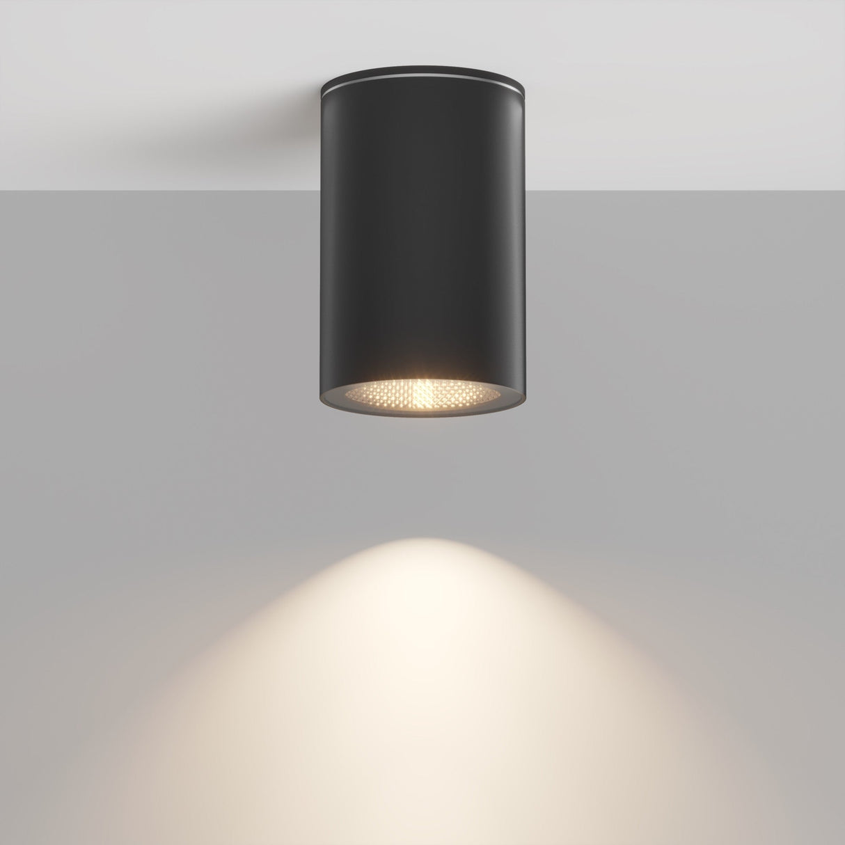 The Roll Outdoor Downlight - Black’s modern aluminum design casts a warm, focused beam onto the gray surface, enhancing the elegant ambiance with its minimalistic look. Its also reliable with an IP54 protection rating.