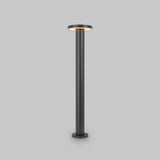 The Wald LED Bollard Light 3000K 12W in Graphite features an 80cm sleek, modern design with a black stand and a flat circular LED light on top, emitting a soft glow. It stands elegantly against a gray background, offering the sophisticated style of outdoor lighting indoors.