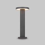 The Wald LED Bollard Light 3000K 12W features a modern cylindrical design, stands at 40cm, boasts a graphite finish and emits soft light from the circular top against a light gray background.