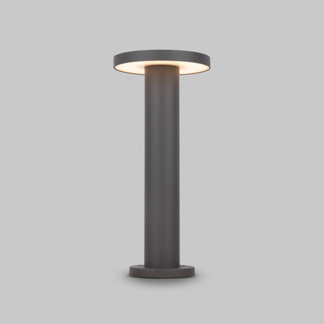 The Wald LED Bollard Light 3000K 12W features a modern cylindrical design, stands at 40cm, boasts a graphite finish and emits soft light from the circular top against a light gray background.