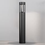 The Vint LED Bollard Light 3000K 9W - Graphite, 60cm features a sleek, modern design with a tall cylindrical shape and an open-topped metal lantern. Its graphite finish emits a soft glow against neutral surroundings, ideal for enhancing outdoor lighting ambiance.
