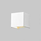 The Fulton Outdoor LED Rectangular Wall Light - White is made from corrosion-resistant aluminum, featuring a minimalist white cube on a grey background. Its energy-efficient LED modules emit a soft glow from the bottom.