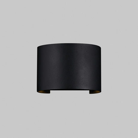 The Fulton Outdoor LED Oval Wall Light - Black features a minimalist, cylindrical design with an open top and bottom, made from corrosion-resistant aluminum, and mounted on a plain gray background.