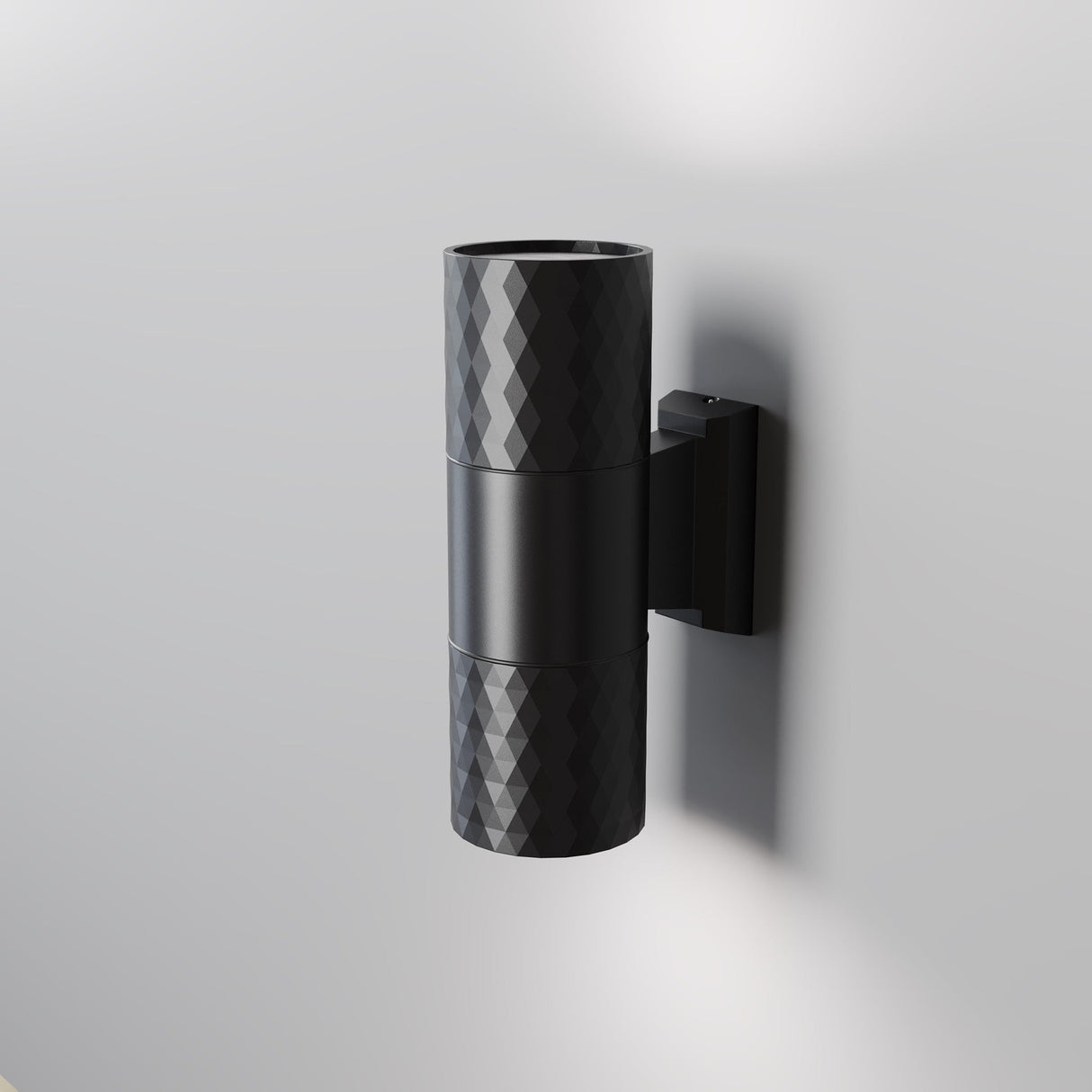 The Bowery Outdoor 2 Light Wall Light (O583WL-02B) is a black, modern metal fixture with a textured diamond pattern, mounted on a gray wall. Its cylindrical design emits light from both ends, making it an ideal sleek and minimalistic choice for any outdoor setting.
