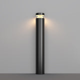 The minimalist Olten Bollard Light 80cm in Graphite, with its cylindrical base and round top, emits a soft, warm LED glow onto the light gray wall.
