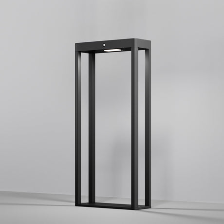A modern, sleek graphite standing lamp with an open rectangular design sits against a plain gray background. The Pir LED Pedestal Light with Motion Sensor at the top softly illuminates the interior with a stylish glow.