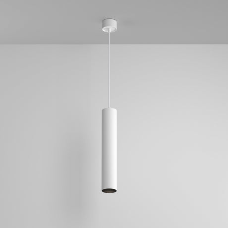 The Artisan 1 Light Long Round Pendant, featuring a sleek white finish and minimalist cylindrical design, hangs elegantly from the ceiling against a plain wall, embodying modern lighting design.