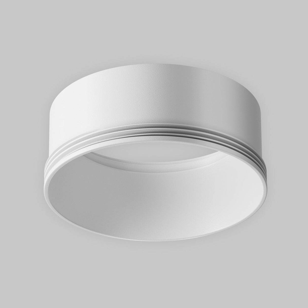 The Focus LED Large Decorative Ring for Track Spotlight in white features a modern, minimalist design. Its sleek circular shape complements a gray ceiling, providing a contemporary look ideal for diverse interior settings.