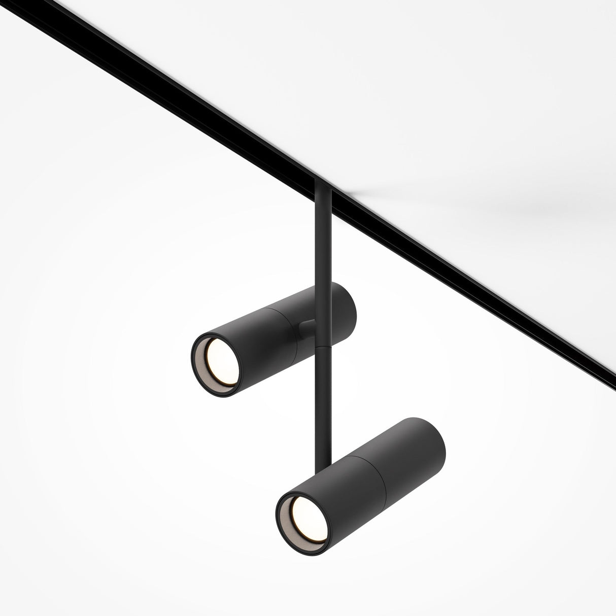 The Elti Duo LED Magnetic Exility Track Spotlight 24W 3000K - Black is a sleek, modern ceiling light with two cylindrical spotlights on a central rod, ideal for contemporary interiors. Each spotlight elegantly illuminates from the white ceiling with its minimalist design.