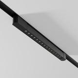 The Points Rot LED Swivel Linear Track Light, black and minimalist with 4000K cool white lights, mounts on a white ceiling. This 22W fixture for single-phase tracks has high CRI, offering a vibrant and contemporary look with its evenly spaced and adjustable design.