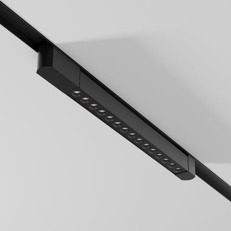 The Points Rot LED Swivel Linear Track Light, black and minimalist with 4000K cool white lights, mounts on a white ceiling. This 22W fixture for single-phase tracks has high CRI, offering a vibrant and contemporary look with its evenly spaced and adjustable design.