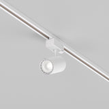 The Vuoro S 3-Circuit Trinity Track LED Spotlight 10W 4000K in white is mounted on a track, illuminating the light gray ceiling with precise directional control.