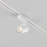The Vuoro S 3-Circuit Trinity Track LED Spotlight in white features a modern cylindrical design, emits a warm 3000K glow, and enhances minimalist aesthetics. Its neutral colors, along with an adjustable swivel mechanism, offer flexible illumination.