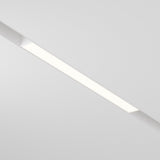 The Basis LED Linear Track Light for Magnetic Exility 12W 3000K - White is a ceiling-mounted fixture featuring sleek design and Warm Glow Lighting, casting an even white glow against a plain white ceiling.