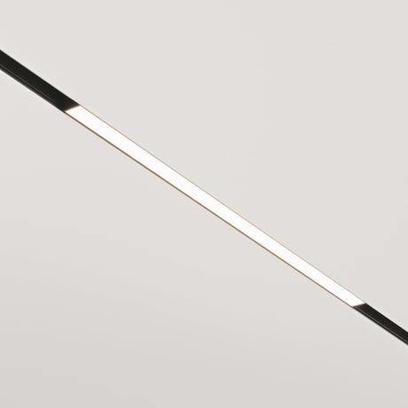 A minimalist image features the Basis LED Linear Track Light for Magnetic Exility 24W 4000K - Black, elegantly arranged diagonally on a plain, light-colored ceiling. It emits a soft, even glow, enhancing the space with a sleek and contemporary look.