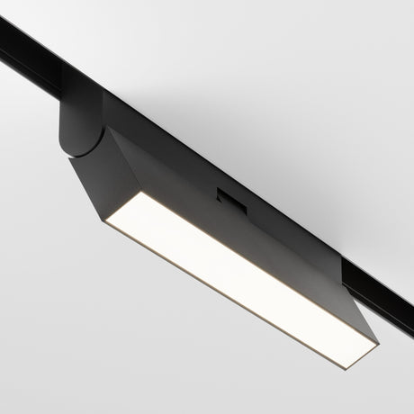 The Basis Rot DALI CCT LED Dimmable Adjustable Linear Track Light, with a sleek black design, hangs from a white ceiling emitting 12W of adjustable light (2700-6000K) perfect for contemporary energy-efficient spaces and mood settings.