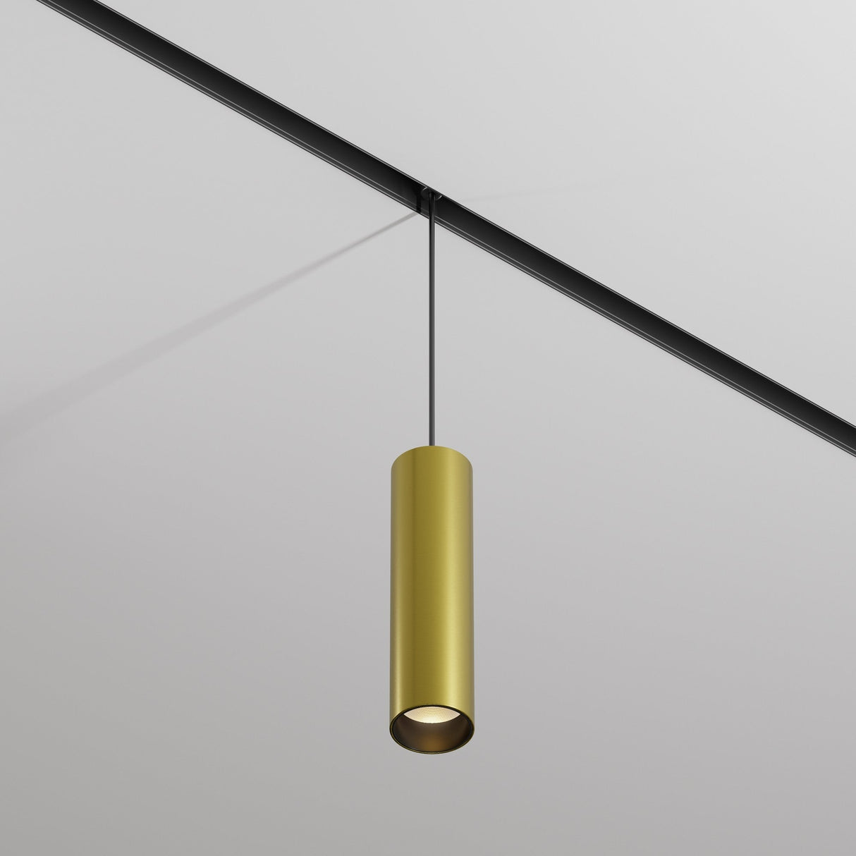 The Focus LED CCT Smart Dimmable Exility Magnetic Track Pendant Light, 12W 2700-6000K in Black & Brass, hangs from a track system on a white ceiling. With its modern cylindrical design, it offers dimmable lighting for a sleek, contemporary vibe.