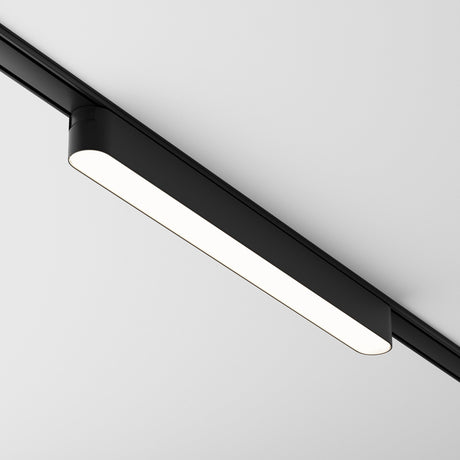 The Basis LED Linear Track Light for Magnetic Tracks Radity 16W 4000K - Black offers a sleek, minimalist design. Mounted flush against a white ceiling, its high color rendering index ensures bright, clear, and even illumination throughout the space.