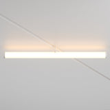 The Larc LED Rotating Linear Track Light for Magnetic Exility (25W, 3000K) emits a warm glow from the white ceiling, casting soft shadows and diagonal lines across the surface with its minimalist cylindrical design.