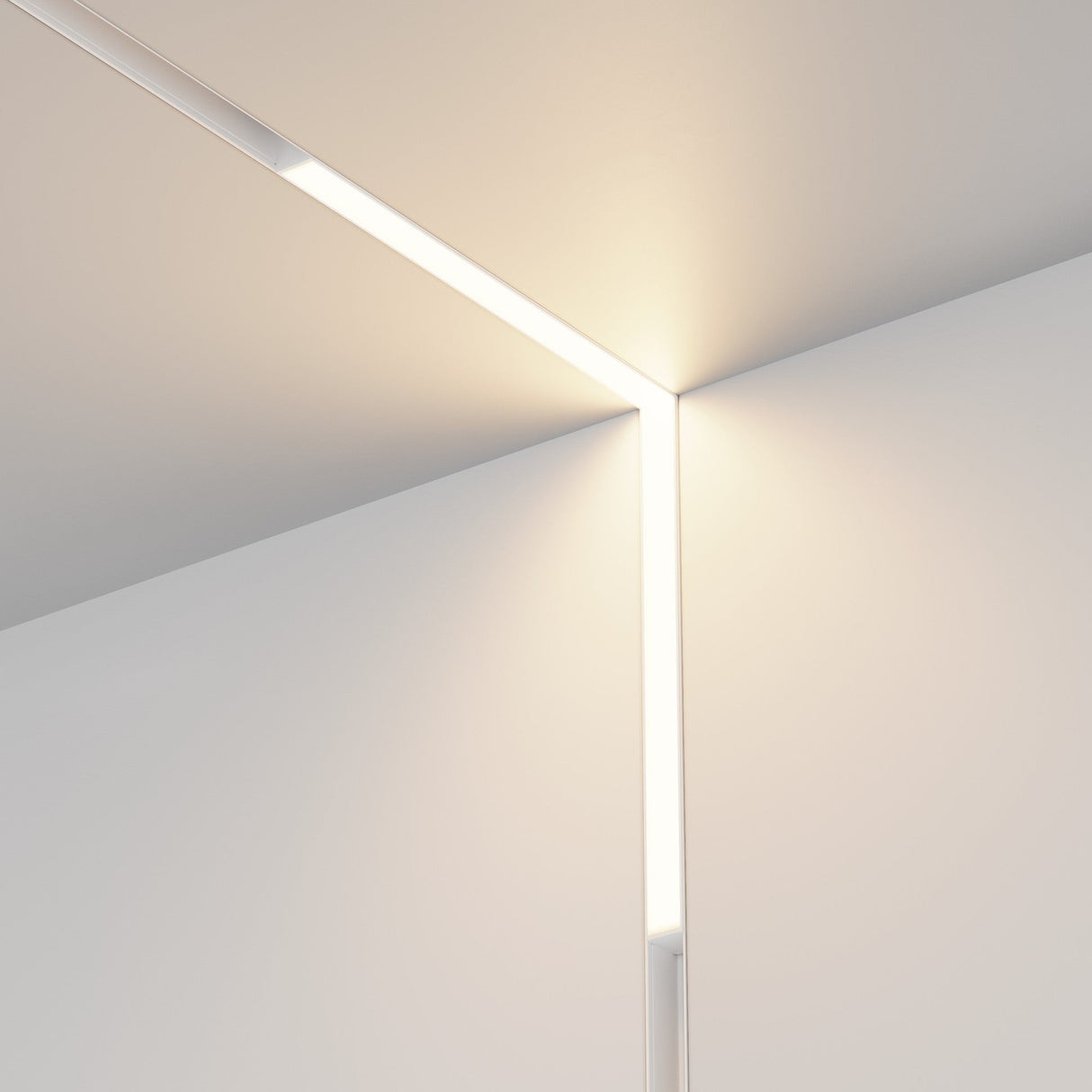 Minimalist room corner with sleek lighting. The Basis Angle CCT LED Dimmable 90° Linear Track Light, with its magnetic Exility and range of 2700-6000K, gracefully illuminates the walls and ceiling junction, casting a serene, diffused glow along the edges.