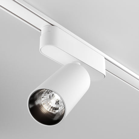The Focus LED Magnetic Radity Track Spotlight 12W 4000K in white is mounted on a white ceiling. Its reflective cylindrical design efficiently directs downward accent lighting, making it energy-efficient and perfect for contemporary settings.