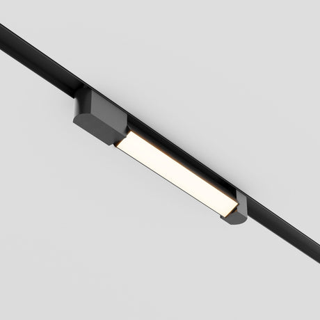 The Basis Rot LED Swivel Linear Track Light (12W, 3000K) mounts on a black aluminum track against a white ceiling. Its sleek and modern design includes a matte polycarbonate diffuser and rectangular shape, providing a soft glow that complements its contemporary aesthetic.