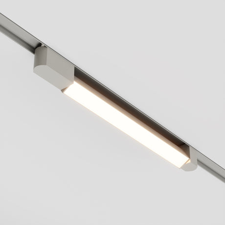 The Basis Rot LED Swivel Linear Track Light, a sleek 24W fixture with a minimalist design, featuring an illuminated strip and adaptable swivel. It mounts on a single-phase rail against a white ceiling, providing versatile lighting in 3000K.