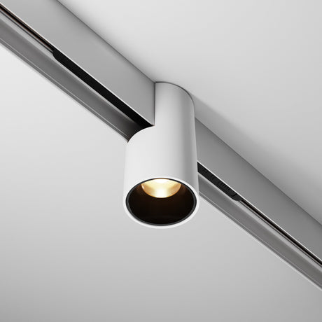 The Alfa LED Magnetic Exility Track Downlight 7W 3000K - White offers a minimalist, cylindrical design. It mounts on a sleek track, emitting a soft, warm glow that complements the smooth white ceiling elegantly.