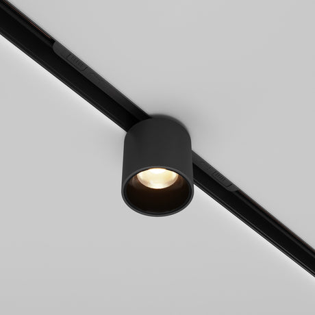 The Alfa S LED Magnetic Exility Track Downlight 7W 3000K in black is ideal for modern interiors, with a cylindrical fixture on a white ceiling. Its warm, focused glow and flexible positioning blend seamlessly into contemporary designs.