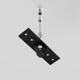 The Exility Magnetic Surface-Mounted Track Suspension Cable in Black features an industrial-chic design with a sleek black rectangle and circular cutouts, suspended by a magnetic cable and silver rod against a white background.