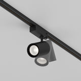 The Vuoro S 3-Circuit Trinity Track LED Spotlight, 26W in black with a cylindrical design and aluminum finish, mounts sleekly on the ceiling with two LED spotlights providing focused illumination against a light gray background.