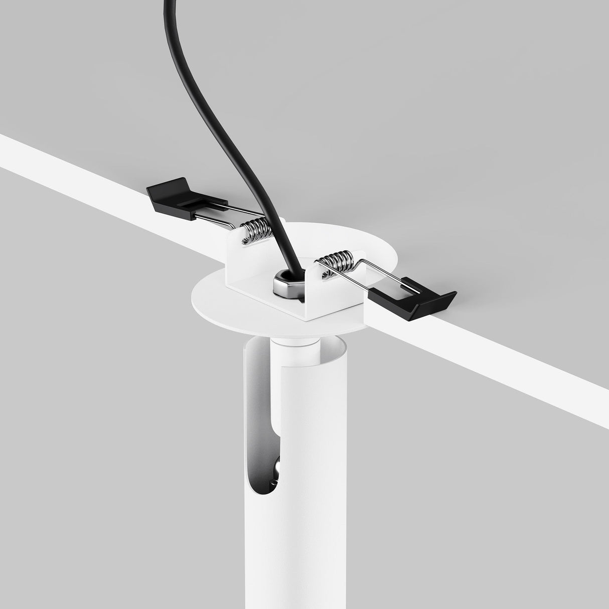 Close-up of a Focus T LED Adjustable Downlight with a black cable through a white plastic grommet secured on a gray tabletop; features spring-loaded clips for secure fastening.