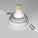A close-up of the Atom Single Tilt Round Recessed Downlight - White (DL025-2-01W) being installed in a light gray ceiling. The white fixture, with metal clips and wires, features contemporary design elements and an adjustable tilt for precise lighting. All parts are neatly aligned for installation.