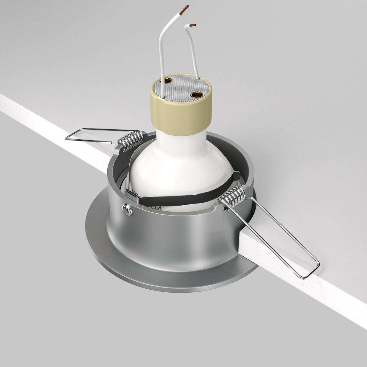 An image shows a Slim Fixed Round Recessed Downlight - Silver being installed in a neutral ceiling. The fixture has cast aluminum housing and two metal clips on the sides, with electrical wires extending from the center.