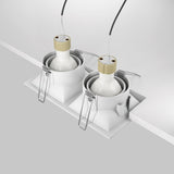 Two Dot Twin Tilt Rectangular Recessed Downlights in white, known for energy-efficient lighting, are positioned side by side on the ceiling. They are shown with exposed wires and metallic clips being installed.