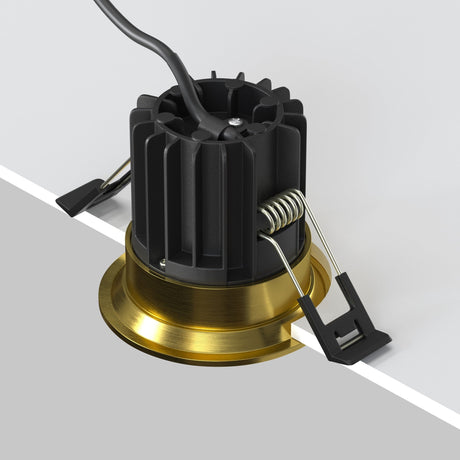 Mounting components for round LED recessed downlight in brass, suitable for a seamless look in modern settings.