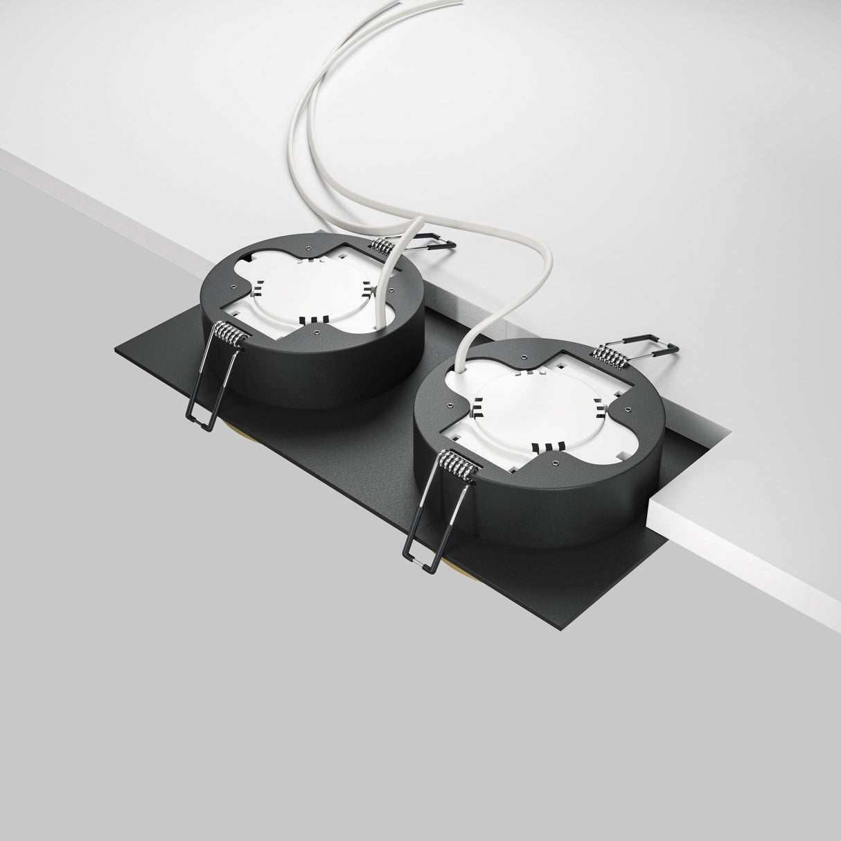 Two Hoop Twin Fixed Rectangular Recessed Downlights in black and gold are installed side by side on a plain white ceiling. Each fixture features LED light sources, with visible wires and metal spring clips for installation.