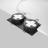 Two Hoop Twin Fixed Rectangular Recessed Downlights in black and gold are installed side by side on a plain white ceiling. Each fixture features LED light sources, with visible wires and metal spring clips for installation.