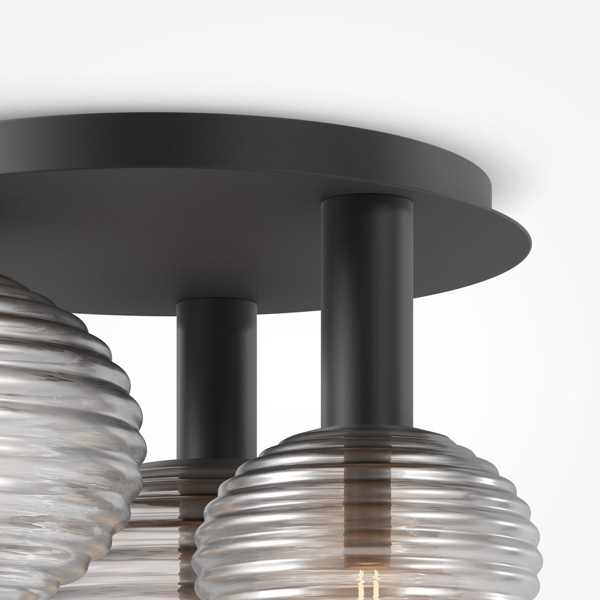 Close-up of the Reels 3 Light Semi-Flush - Black, showcasing its industrial design with three translucent ribbed glass globes on cylindrical black metal stems connected to a circular black base, reflecting the essence of a sleek black ceiling light.