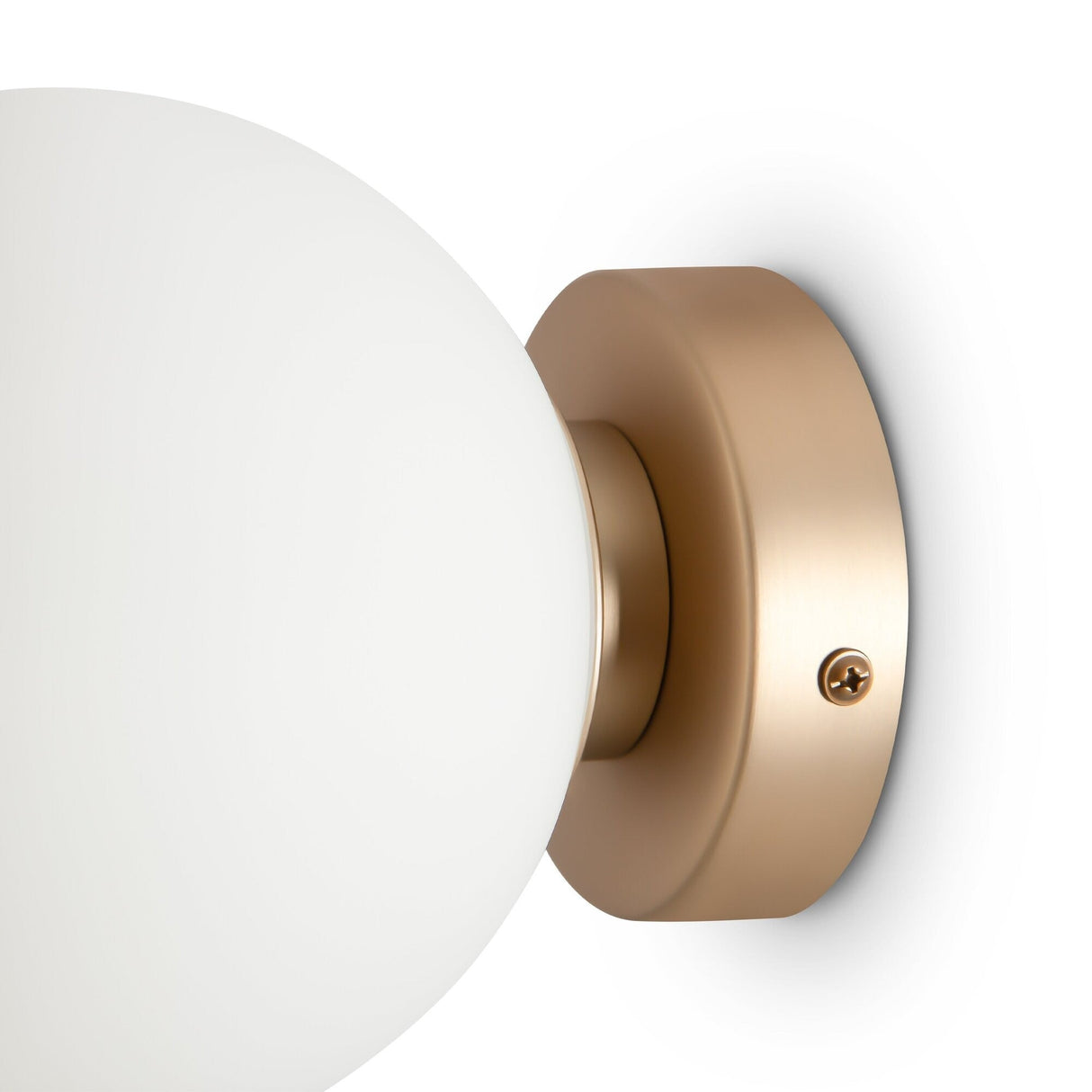 Close-up of the Basic form Small Frosted Ball Wall Light - Gold, showcasing a frosted glass globe on a gold-toned circular base. The wall-mounted fixture offers ambient lighting and is secured with a visible screw.