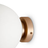 The Basic form Medium Frosted Ball Wall Light - Gold has a frosted glass globe on a circular gold base. A visible screw secures the base, adding to its minimalist style. The fixture is set against a plain white background.